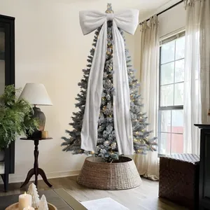 Elegante fiocco natalizio oversize in tessuto bianco con lunghi nastri su un albero