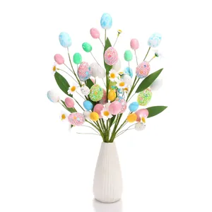 Artificial Easter egg branch with colorful speckled eggs and daisies in a white vase