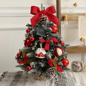 Close-up of 60cm mini Christmas tree with snow, red bows, pine cones and warm LED lights
