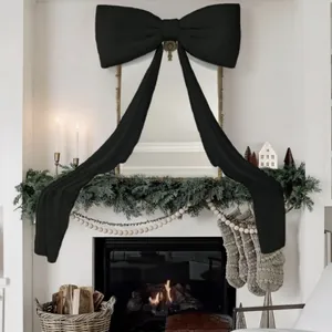 Grande decorazione con fiocco di velluto nero su uno specchio sopra un camino natalizio