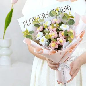 Close-up of handmade crochet daisy bouquet with pink and white flowers in gift wrapping