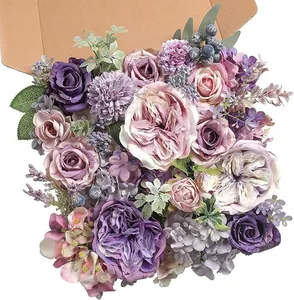 Detalle de caja de flores artificiales púrpuras con rosas, peonías y follaje verde