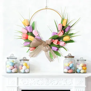 Corona de Pascua con tulipanes de colores y lazo de arpillera en pared de chimenea