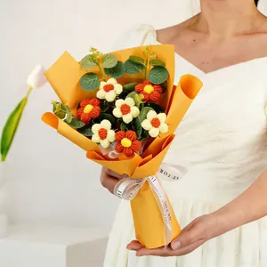 Hand-knitted daisy bouquet in yellow wrapping with a FOR YOU ribbon held by a person