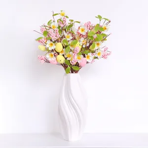 Œufs de Pâques artificiels et fleurs blanches dans un vase en spirale moderne