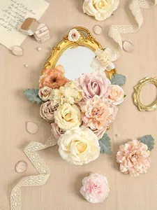 Detalle de flores artificiales en tonos champán y rosa sobre un espejo dorado antiguo