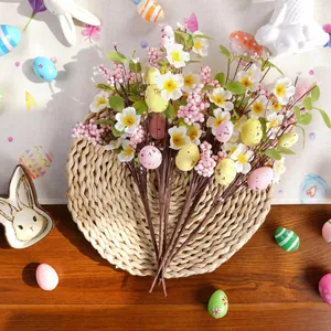 Bouquet d'œufs de Pâques artificiels avec petites fleurs blanches sur set de table