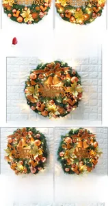 Close-up of lit Christmas wreath with gold bows, bells and warm LED string lights