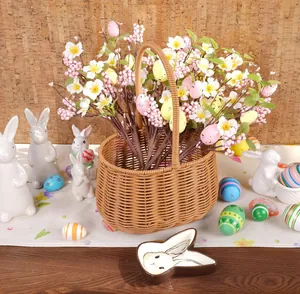 Gros plan d'un panier de Pâques tressé avec fleurs artificielles et œufs colorés