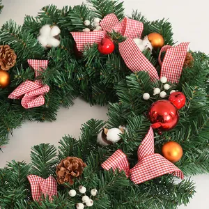 Detail van 2,7m kerstslinger met dennenappels, rode strikken en feestelijke ballen