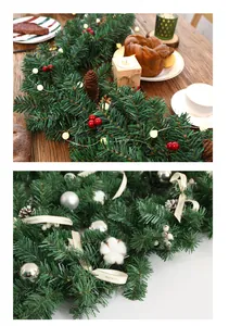 Detail of Christmas garland with pine cones, red berries, and warm LED lights