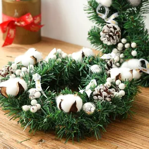 Nordic Christmas wreath with pine needles, cotton, pinecones, and silver balls on wood