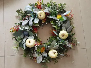 Detailopname van een herfstkrans met witte pompoenen, eucalyptus en bessen
