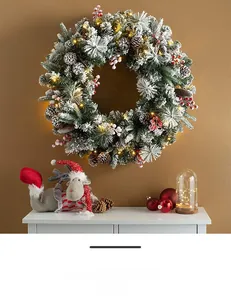 Detail of Christmas wreath with snowy needles, pine cones, berries and warm LED lights