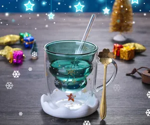 Detail of Christmas tree double wall glass with snowflake patterns and gold star spoon