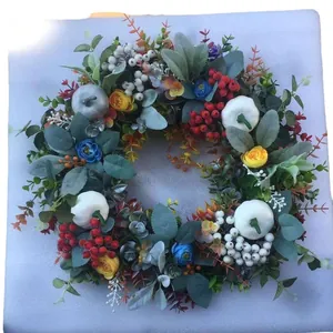 Herfstkrans met kleurrijke pompoenen, rode bessen en eucalyptus voor oogstdecoratie