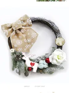 Detail of Christmas wreath with pine cones, burlap bow, and wooden reindeer pendant