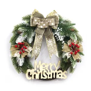 Christmas wreath with green pine needles, red berries, pine cones and Merry Christmas sign