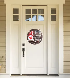 Close-up of Gnome Sweet Gnome wooden door sign with plaid bow on a white door