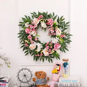 Detailed view of handmade rose floral wreath with pink flowers and lush green foliage