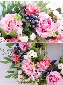 Close-up of pink roses and blue berries on a lifelike floral wreath for wall decor