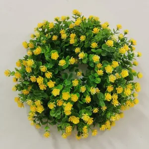 Detalle de corona de Pascua con flores amarillas y hojas de eucalipto para la puerta