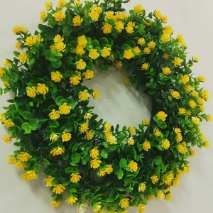 Vista detallada de corona de eucalipto artificial con flores amarillas para decoración primaveral