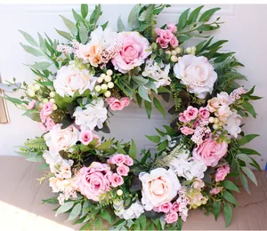 Macro detail of artificial rose wreath with pink blooms and green foliage for decor
