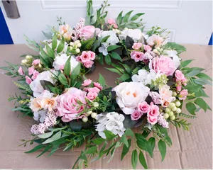 Close-up of handmade floral wreath with pink roses, hydrangeas and green foliage