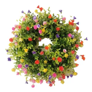 Corona floral de Pascua con hojas de eucalipto y flores de colores para decorar la puerta