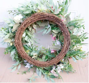 Detailed view of artificial rose wreath with natural vines and greenery for wall decor
