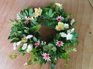 Detail of handmade artificial floral wreath with pink daisies and green eucalyptus leaves