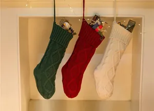 Set of three large knit Christmas stockings in red, green and white with diamond patterns
