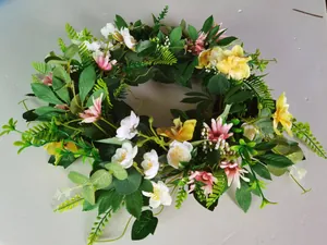 Detail of Easter wreath with pink daisies, yellow orchids and mixed green leaves