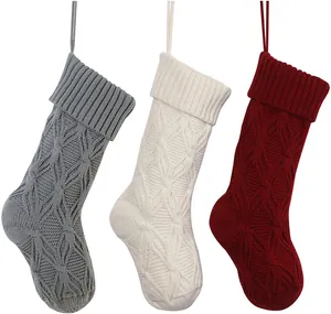 Close-up of three 46cm cable knit Christmas stockings in grey, white, and dark red colors