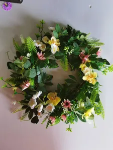 Detail view of Easter floral wreath with yellow orchids, pink daisies and green leaves