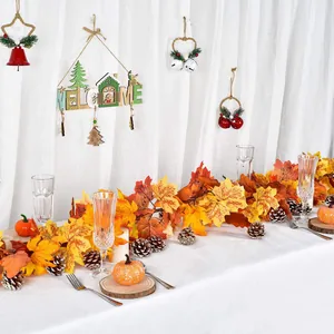 Detailed view of fall maple leaf garland with faux pumpkins and natural pinecones for decor