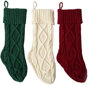 Close-up of thick cable knit patterns on green, cream, and red Christmas stockings