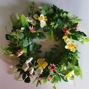 Artificial Easter floral wreath with yellow orchids, pink daisies and green fern leaves