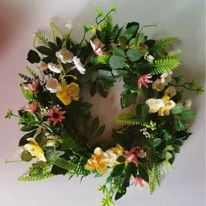 Artificial floral wreath with yellow orchids and pink daisies for Easter wall decoration