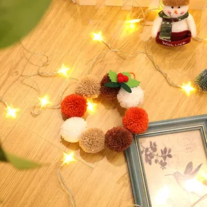 Primer plano de corona navideña de peluche con bolas de colores y hojas de acebo decorativas