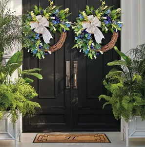 Detail of blue flower wreaths with silver bows hanging on black double front doors