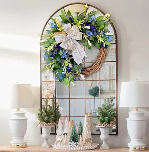 Close-up of spring blue floral wreath with green leaves and a silver glitter bow decoration