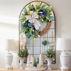 Blue hydrangea spring wreath with a silver bow on a vintage mirror for home decoration