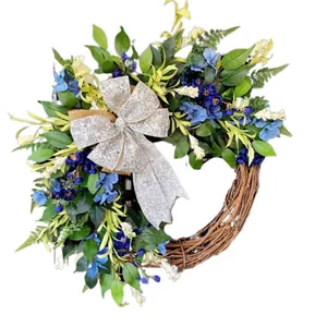 Blue spring wreath with artificial flowers and floral bow on a natural rattan base