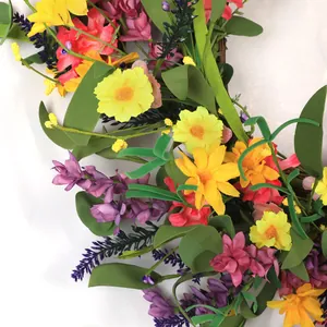 Vibrant summer wreath with daisies, lavender, and mixed flowers on rattan base