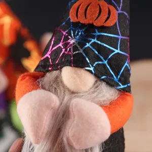 Close-up of Halloween gnome with black pointed hat and orange pumpkin patch detail