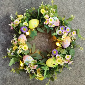 Easter floral wreath with colorful eggs, green leaves, and LED lights for home front door decor