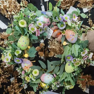 Detail of lit Easter wreath with faux daisies, colorful eggs, and warm white LED lights