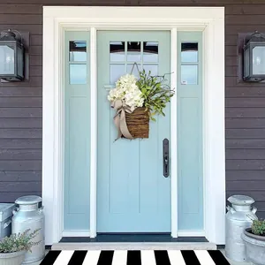 Detail of white hydrangea flower basket with polka dot bow hanging on a rustic blue wooden door